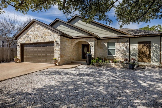 view of front of home with a garage, driveway, and fence