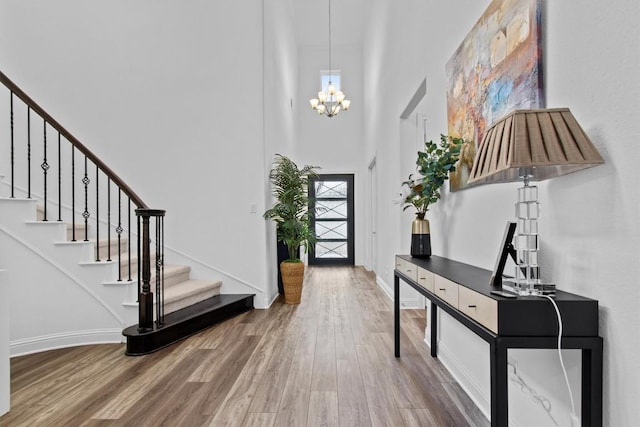4737 Modena Bay Bnd, Leander, TX 78641 - foyer featuring wood finished floors, a towering ceiling, stairway, a chandelier, and plenty of natural light