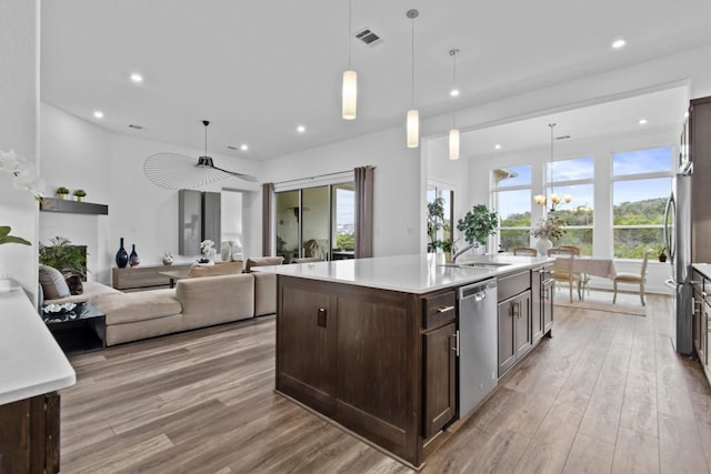 4737 Modena Bay Bnd, Leander, TX 78641 - kitchen featuring stainless steel appliances, dark brown cabinetry, light wood-style floors, recessed lighting, and an island with sink