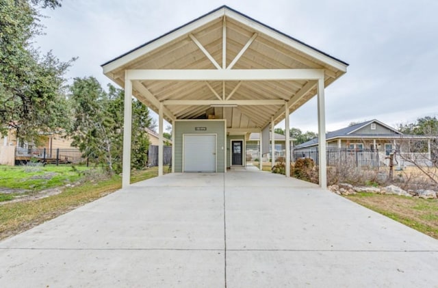 view of parking featuring a garage, a carport, concrete driveway, and fence