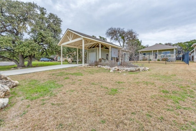 view of front of property featuring a carport, concrete driveway, a front yard, and fence