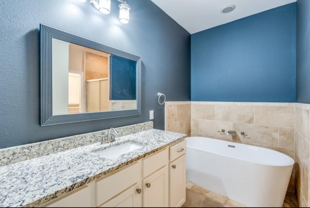 bathroom with a freestanding tub, a shower stall, and vanity