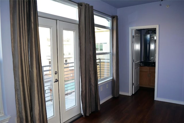 doorway to outside featuring baseboards, dark wood finished floors, and french doors