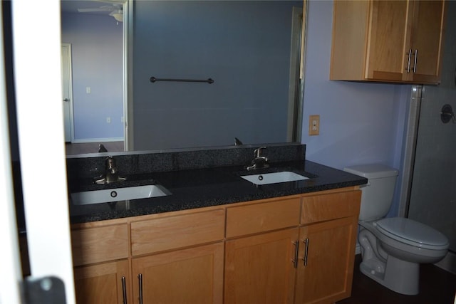 full bath with double vanity, a sink, and toilet