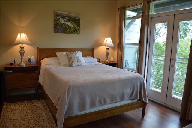 bedroom with french doors, multiple windows, wood finished floors, and access to exterior