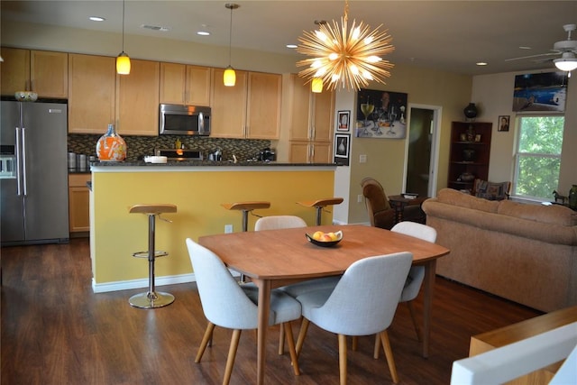 dining area featuring ceiling fan with notable chandelier, dark wood-type flooring, visible vents, and recessed lighting