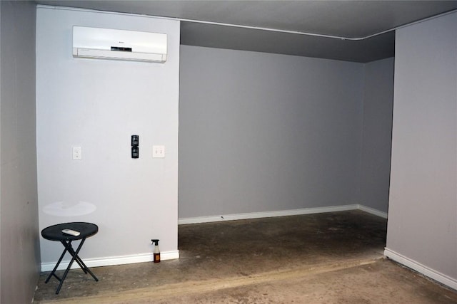 interior space featuring baseboards, unfinished concrete flooring, and an AC wall unit