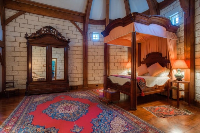 bedroom featuring wood finished floors and beam ceiling