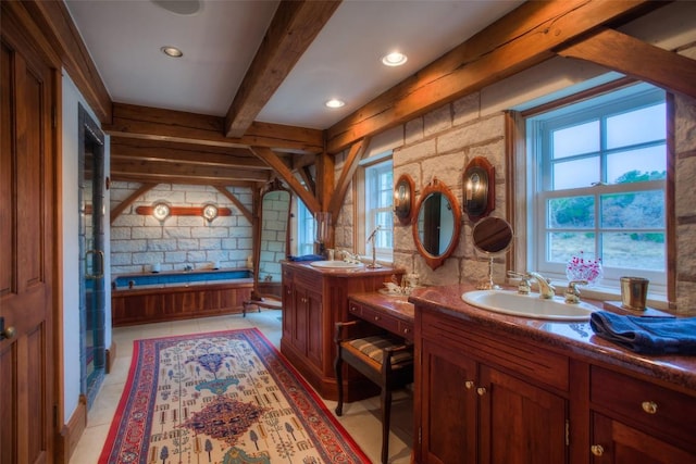 full bathroom featuring a garden tub, beamed ceiling, two vanities, and a sink