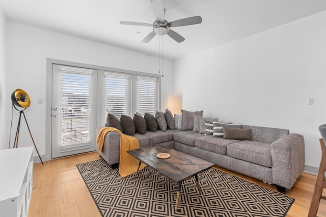 living area featuring light wood-style floors and a ceiling fan