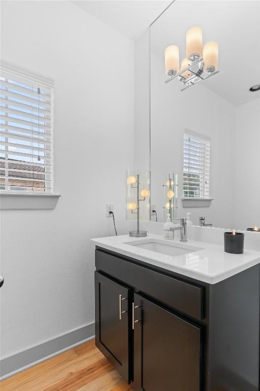 bathroom featuring baseboards, wood finished floors, and vanity