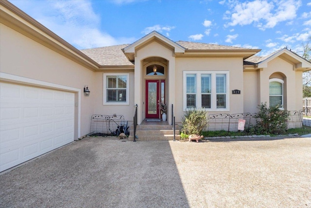 view of front of house featuring a garage, driveway, and stucco siding