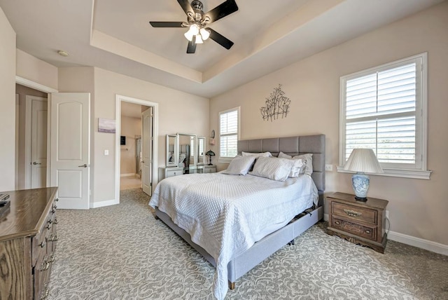 bedroom featuring a ceiling fan, baseboards, a raised ceiling, and carpet flooring