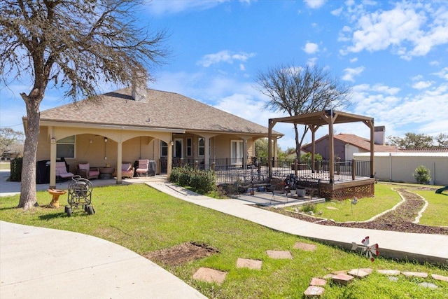 back of house featuring a yard, a shingled roof, a patio area, and fence