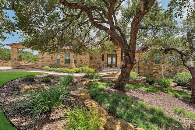 view of front of home featuring stone siding and french doors