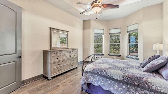 bedroom with wood finished floors, a ceiling fan, and baseboards