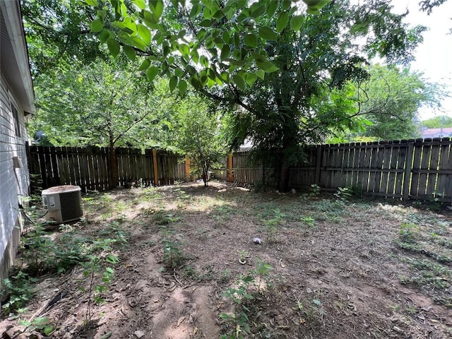 view of yard with central AC unit and a fenced backyard