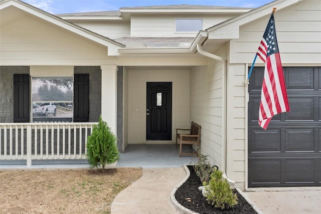 entrance to property featuring a garage and a porch