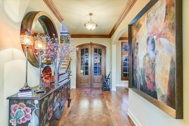 foyer featuring arched walkways, french doors, ornamental molding, wood finished floors, and baseboards