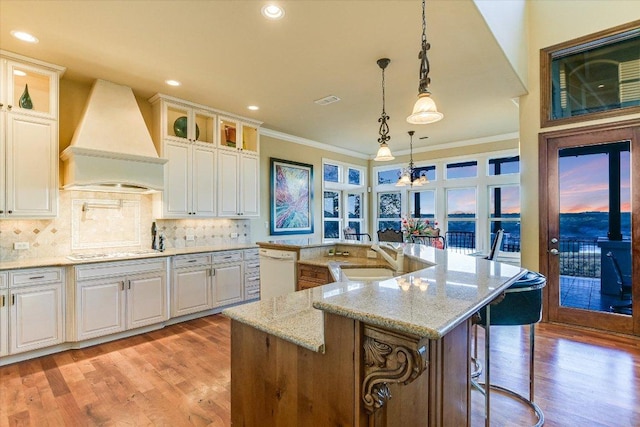 kitchen featuring tasteful backsplash, white appliances, premium range hood, and glass insert cabinets