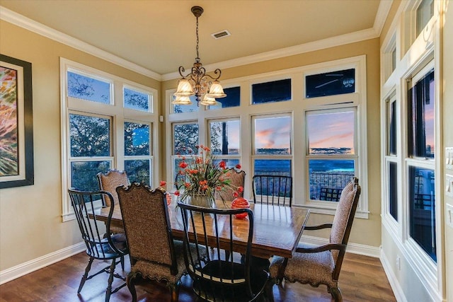 dining area featuring ornamental molding, visible vents, and dark wood finished floors