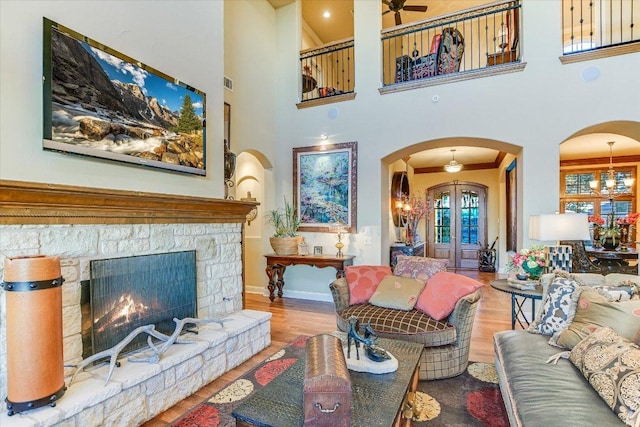 633 Wesley Ridge Dr, Spicewood, TX 78669 - living room with arched walkways, wood finished floors, baseboards, a towering ceiling, and a ceiling fan
