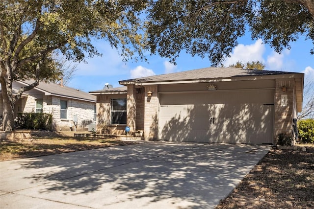 ranch-style house featuring a garage, concrete driveway, and brick siding