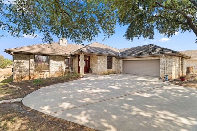 1306 Far W Rd, Horseshoe Bay, TX 78657 - view of front facade with a garage, stone siding, driveway, a chimney, and a tile roof