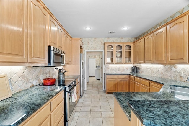 1306 Far W Rd, Horseshoe Bay, TX 78657 - kitchen featuring stainless steel appliances, glass insert cabinets, dark stone counters, light tile patterned floors, and recessed lighting