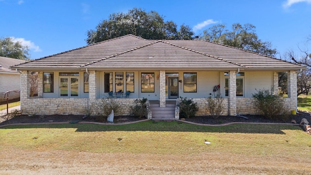 1306 Far W Rd, Horseshoe Bay, TX 78657 - view of front of home with stone siding, a front yard, covered porch, and a tiled roof