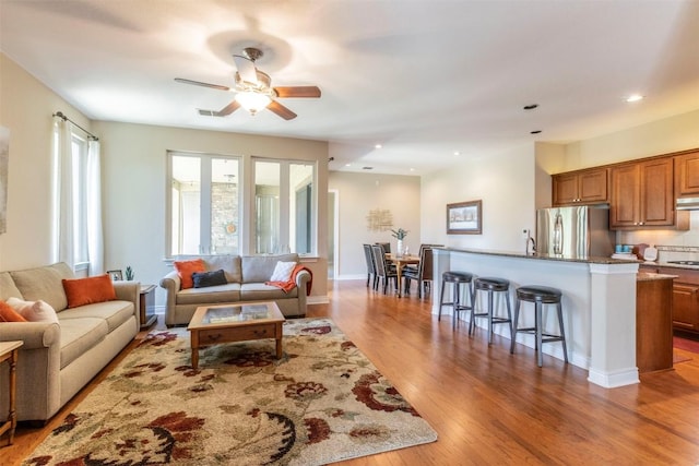 living room with ceiling fan, visible vents, wood finished floors, and recessed lighting