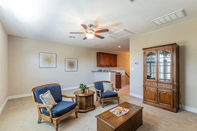 sitting room featuring attic access, visible vents, light carpet, and baseboards