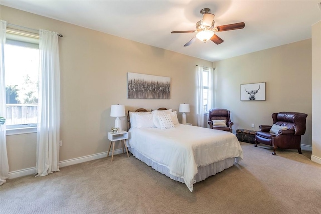 bedroom with baseboards, a ceiling fan, and light colored carpet