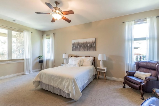 bedroom with light carpet, ceiling fan, and baseboards