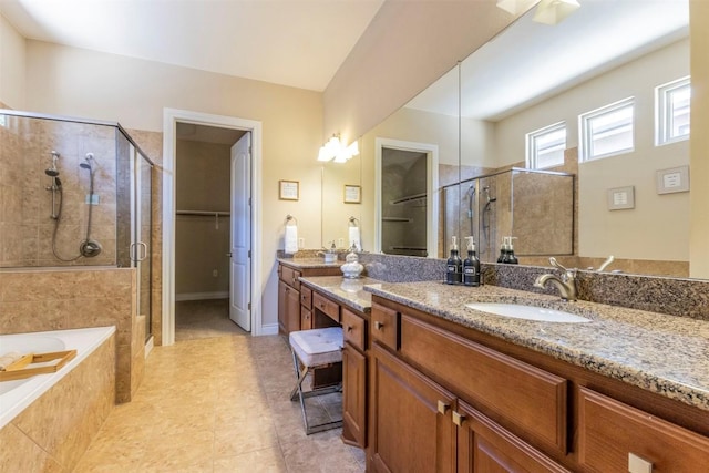 full bath with a garden tub, vanity, a spacious closet, a shower stall, and tile patterned floors