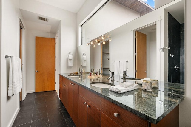 bathroom featuring double vanity, baseboards, visible vents, tile patterned flooring, and a sink