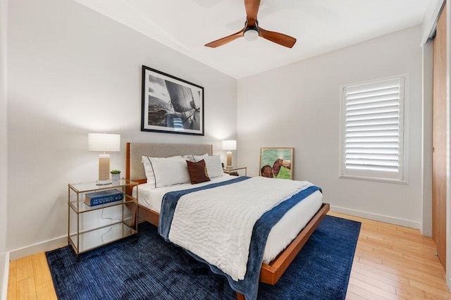 bedroom featuring a ceiling fan, baseboards, and hardwood / wood-style floors