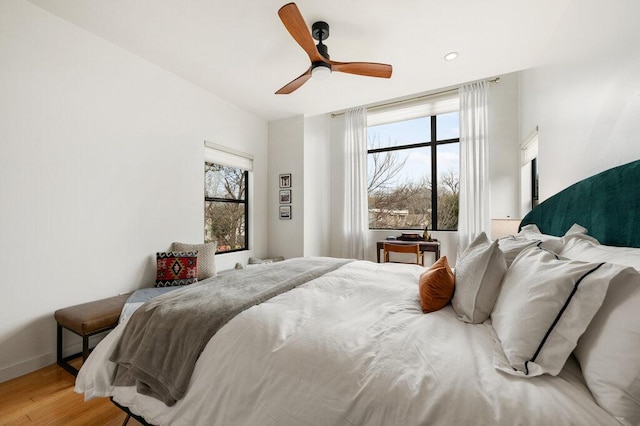 bedroom featuring a ceiling fan, baseboards, and wood finished floors