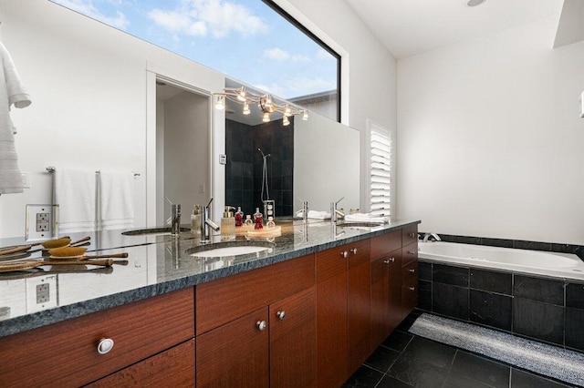 bathroom with a garden tub, a tile shower, a sink, and tile patterned floors