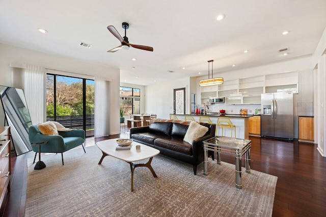 living area with a ceiling fan, dark wood-style flooring, visible vents, and recessed lighting