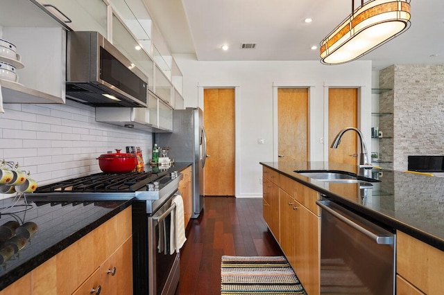 kitchen with visible vents, dark wood-style floors, a sink, stainless steel appliances, and backsplash