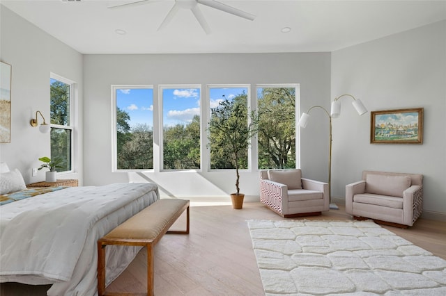 bedroom with a ceiling fan, baseboards, and wood finished floors