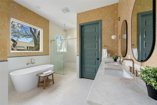 full bath with a stall shower, a sink, a freestanding bath, and double vanity