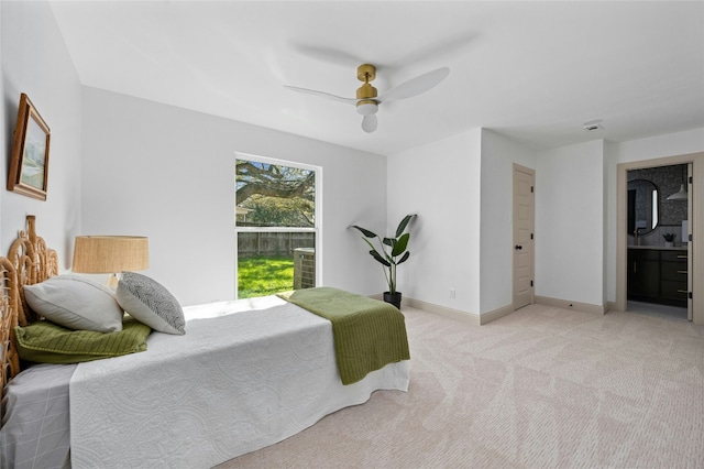 bedroom with carpet floors, ensuite bath, baseboards, and a ceiling fan