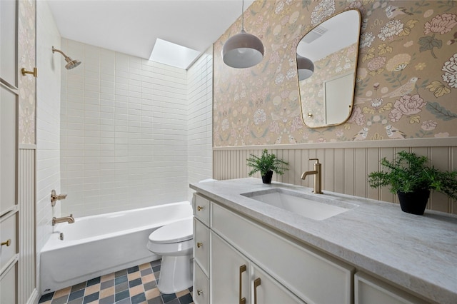 full bath with wallpapered walls, a skylight, wainscoting, toilet, and shower / washtub combination