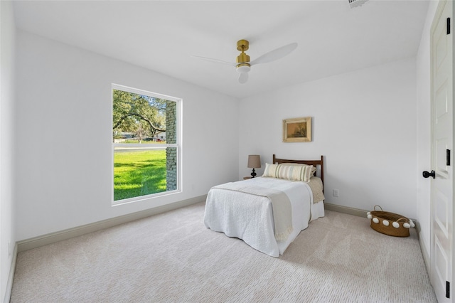 carpeted bedroom with ceiling fan and baseboards