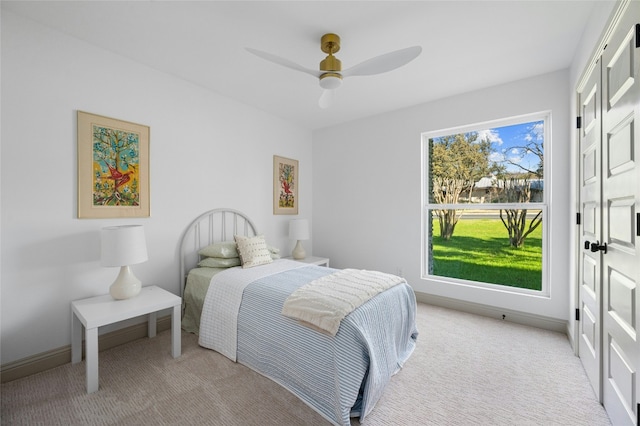 bedroom featuring light carpet, ceiling fan, and baseboards