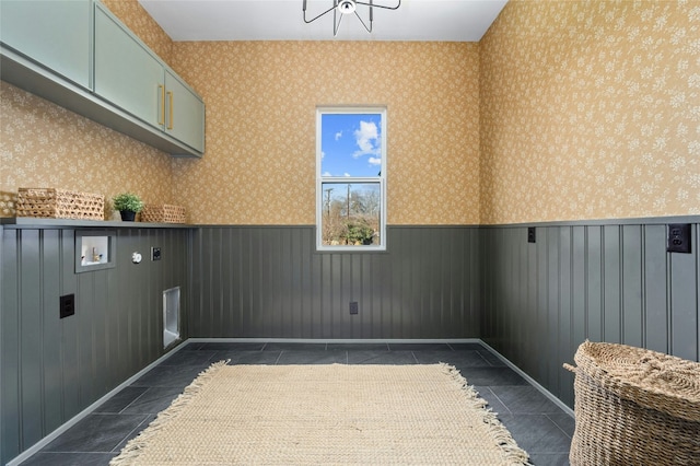 laundry area featuring cabinet space, hookup for a washing machine, wallpapered walls, and wainscoting