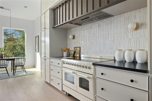 kitchen featuring light wood-style flooring, white cabinets, backsplash, double oven range, and dark countertops