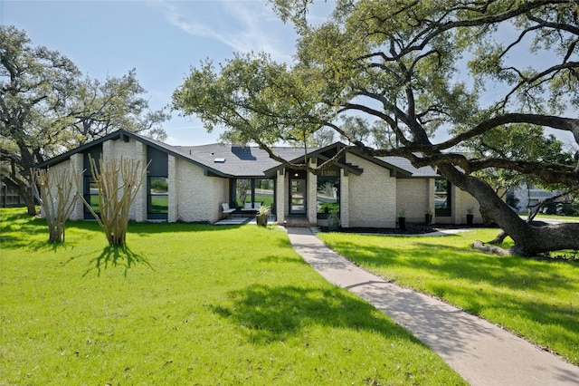 mid-century modern home with a front lawn